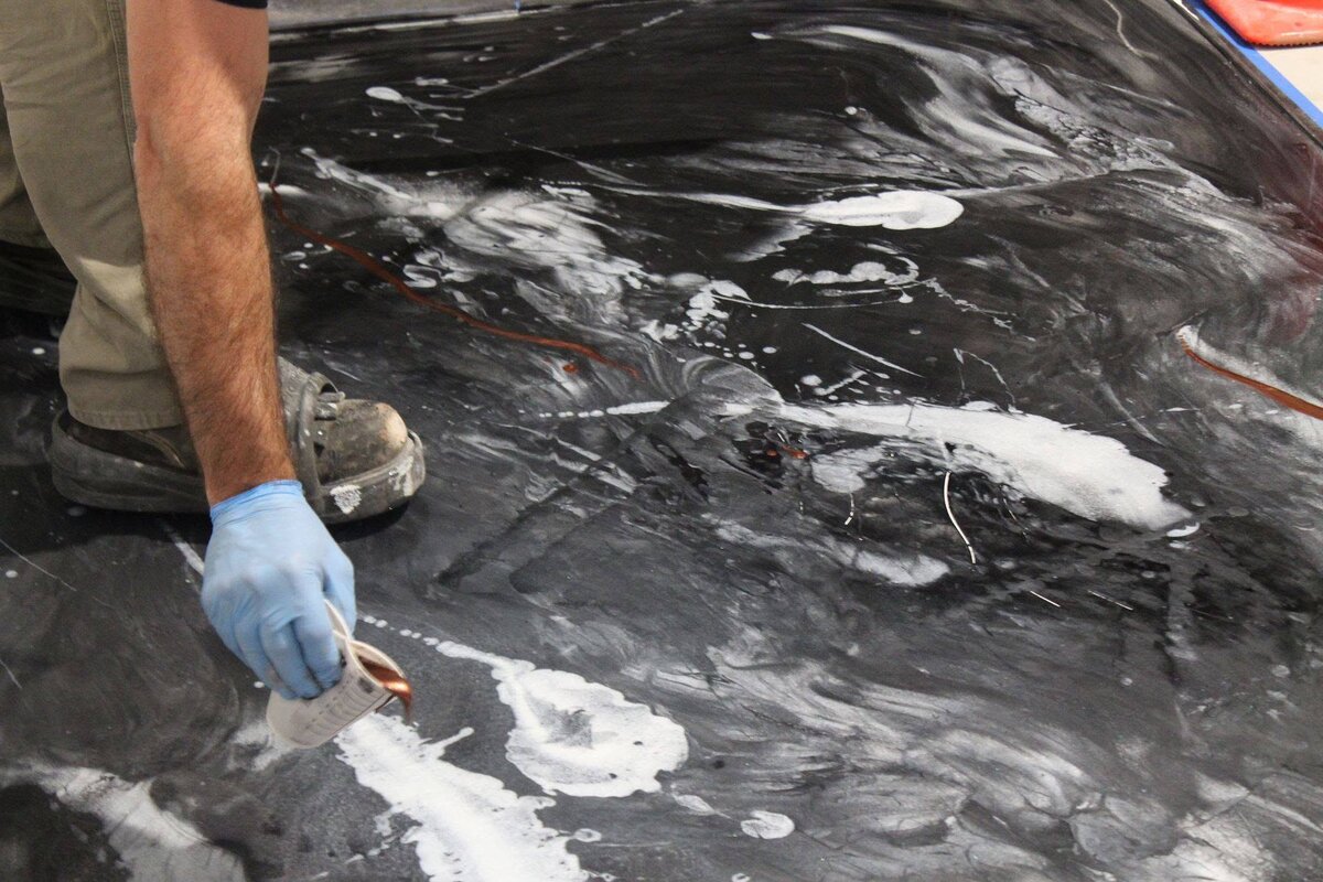 Installer hand-troweling metallic epoxy during installation